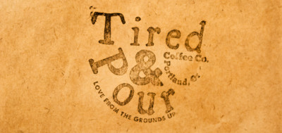 Tired & Pour logo imprinted on the side of a brown paper bag