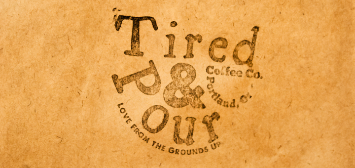 Tired & Pour logo imprinted on the side of a brown paper bag