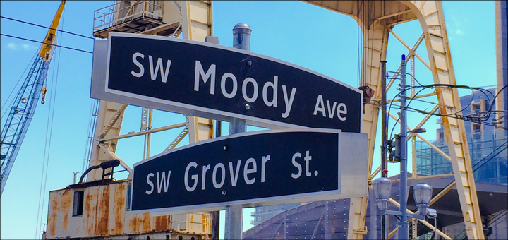 The street signs for SW Moody Ave and SW Grover St outside The Gantry at Zidell Yards food cart pod