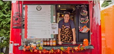 Leah Tucker leaning out of the service window of the City Slickers food cart